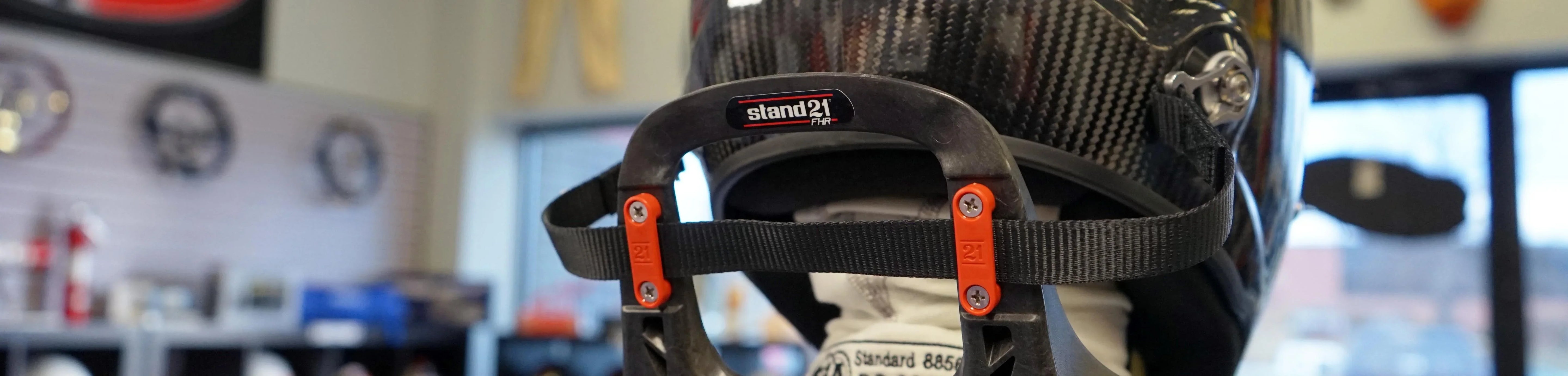 Stand 21 head and neck restraints and racing safety gear used in professional auto racing environments
